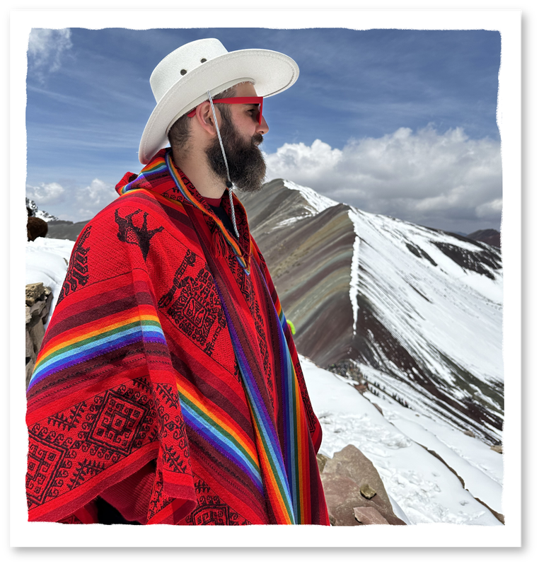 Jordi Luke in a rainbow poncho in the snowy Andes